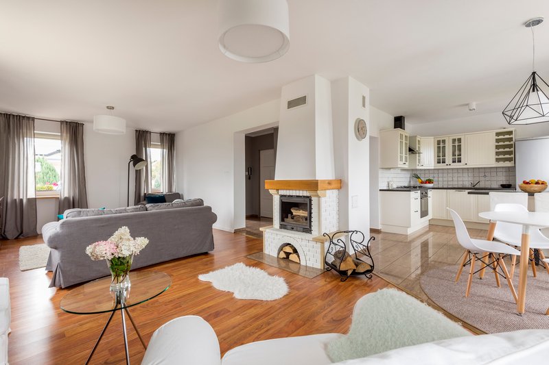 vista de comedor, sala de estar y cocina con una chimenea acogedora